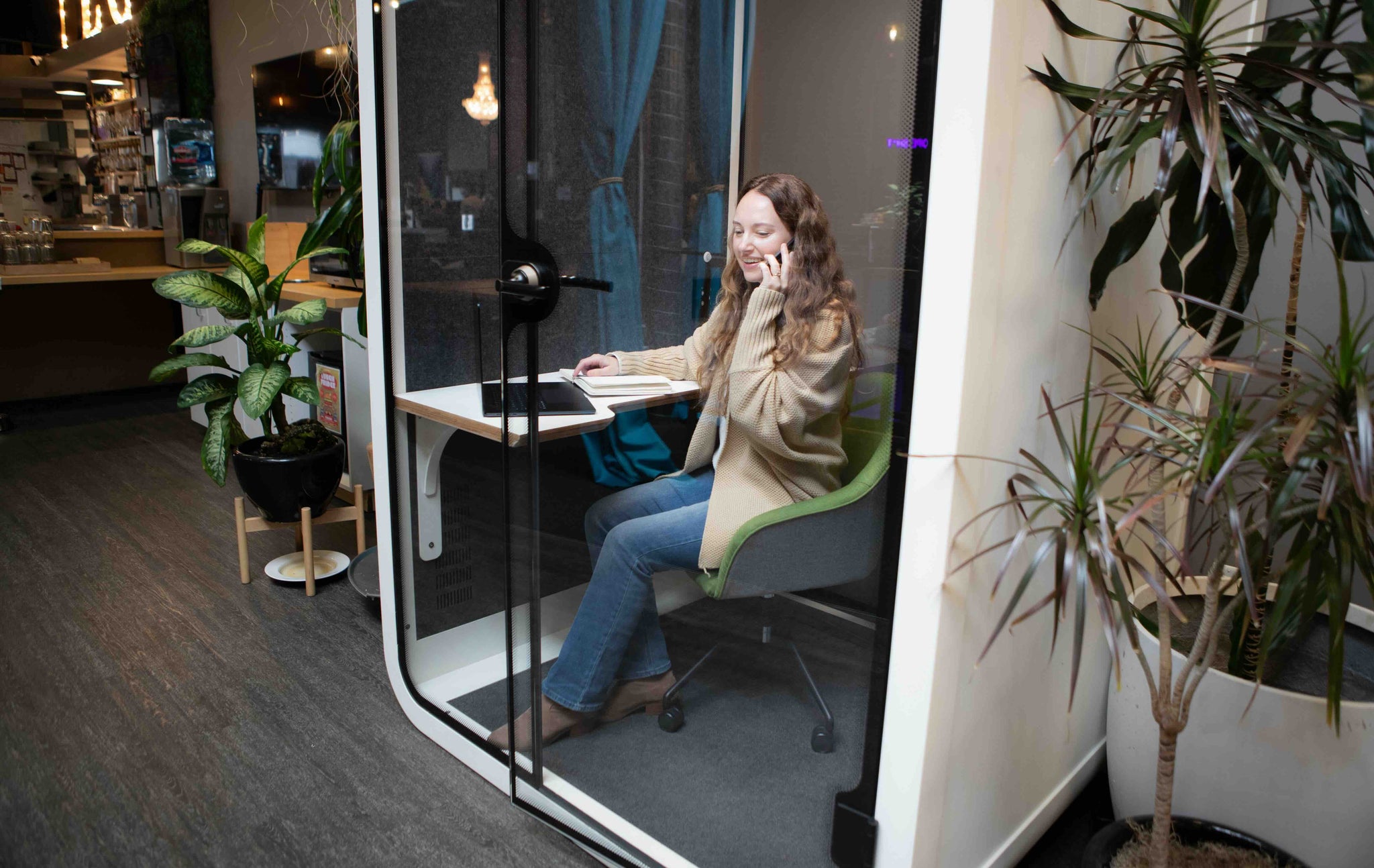 A woman takes a phone call inside a Zoom Room office phone booth at the San Francisco Thinktanks showroom.